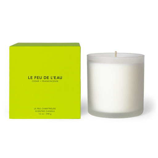 Discover the 12oz Chartreuse candle, blending cedar, sandalwood, and frankincense in Apricot and Coconut wax. With lead-free cotton wicks and a burn time of 65 hours, each candle brings a touch of artisanal luxury. Made in Los Angeles by LE FEU DE L'EAU and packaged in unique linen-textured paper. The candle is displayed unboxed, positioned beside its packaging, set against a clean white backdrop.