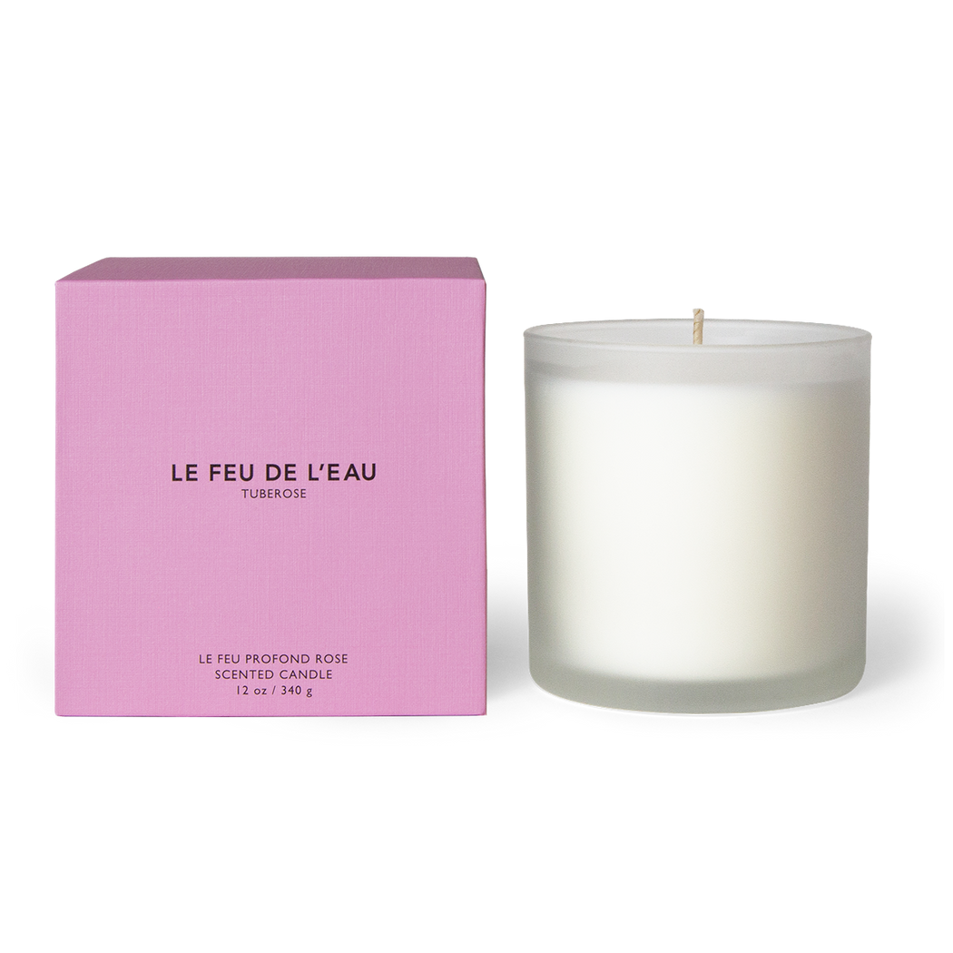 Discover the 12oz Petale candle, blending tuberose, jasmine, orange blossom in Apricot and Coconut wax. With lead-free cotton wicks and a burn time of 65 hours, each candle brings a touch of artisanal luxury. Made in Los Angeles by LE FEU DE L'EAU and packaged in unique linen-textured paper. The candle is displayed unboxed, positioned beside its packaging, set against a clean white backdrop.