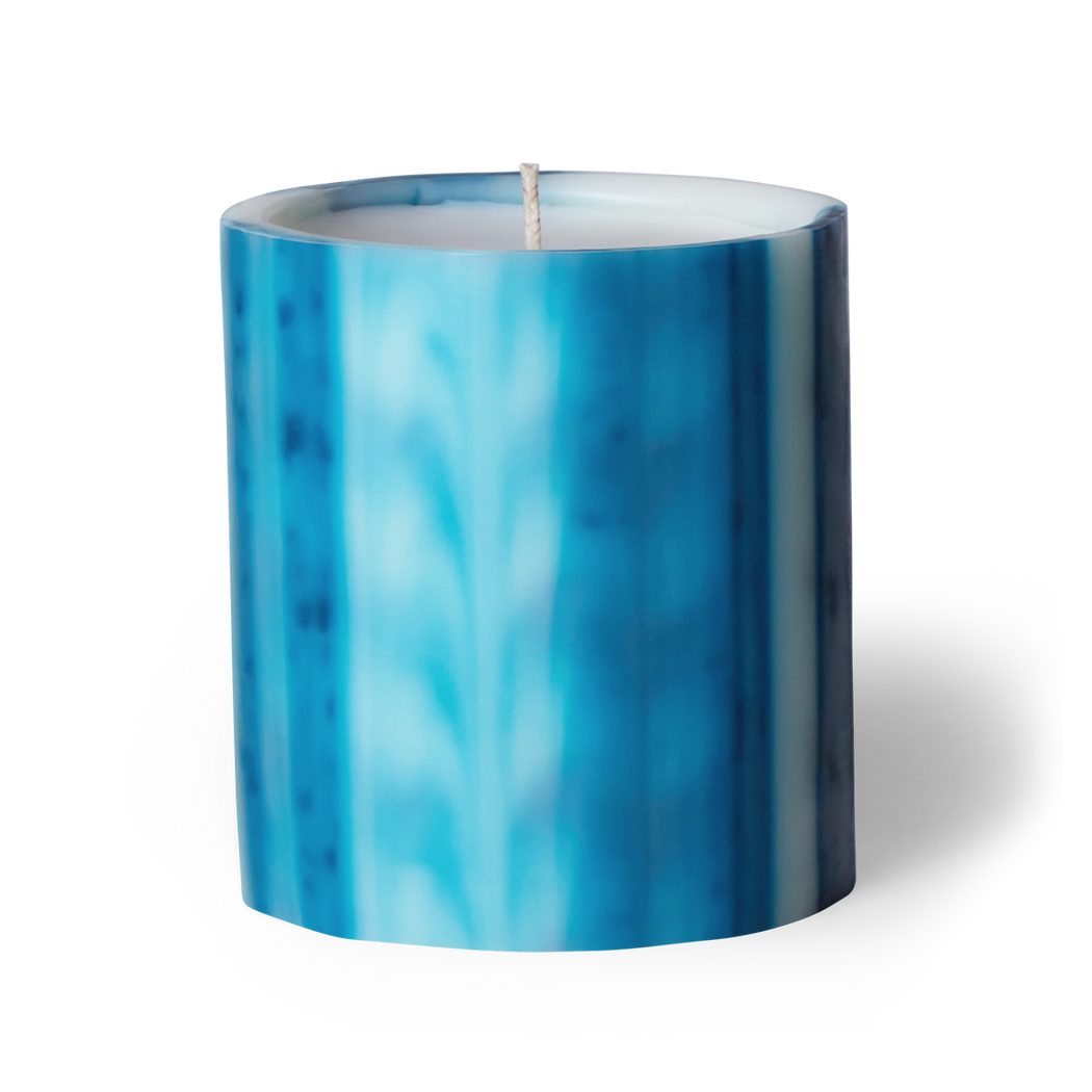 Immerse yourself in romance with Ciel scented artisanal candle. Night blooming jasmine, gardenia, and musk create transportive swells. Crafted underwater from wax, each candle is unique. Hand-poured in LA with cruelty-free coconut apricot wax. Enjoy over 75 hours of burn time. Paraben-free. Natural fragrance.  Image of ciel scented candle in blue wax vessel.