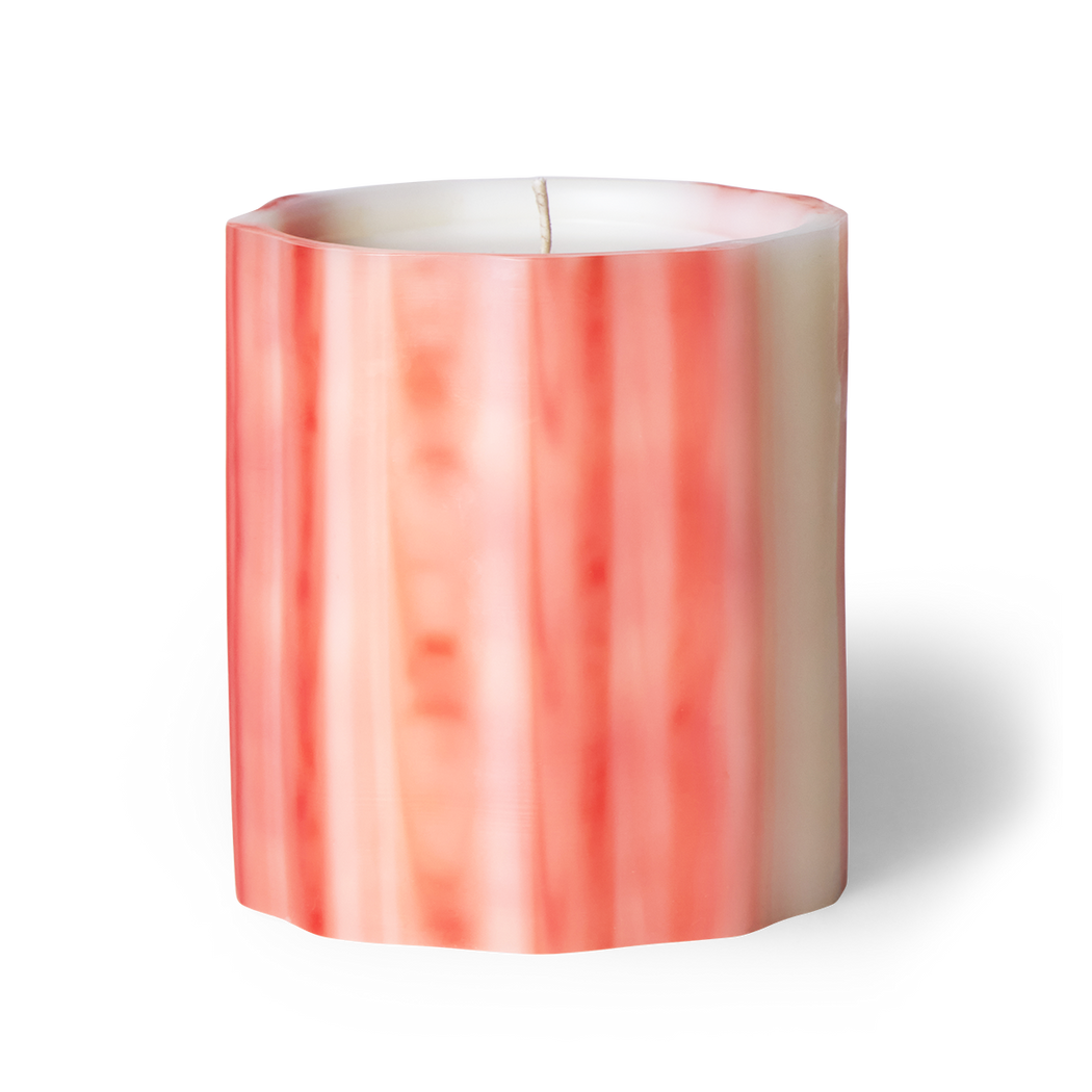 Awaken the senses with fleur scented artisanal candle. Neroli blossom, hibiscus, and citrus peel evoke the vibrance of spring. Handcrafted underwater from wax, each candle is a unique creation. Hand-poured in LA with cruelty-free coconut apricot wax. Enjoy over 75 hours of burn time. Image of fleur scented candle in pink colored waxed vessel.