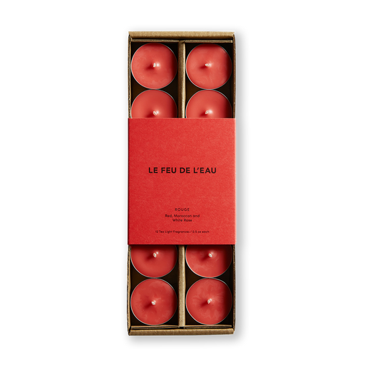 Indulge in the allure of Rouge scented tea light candles by Le Feu De L'eau, merging red, Moroccan, and white rose. Awaken your senses with musky geranium and sweet Moroccan rose. Set of 12, cruelty-free, coconut apricot wax, and natural fragrance. Clean burn, lead-free wicks. Paraben-free. Natural fragrance. Image of red tea light candles inside a box with matching red packaging.