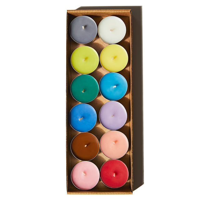 Discover the essence of Le Feu De L'eau scented rainbow tea light candles, featuring all 12 fragrances from the Artisanal Collection. Each set meticulously poured in small batches in Los Angeles, crafted with cruelty-free coconut apricot wax and natural fragrance. Clean burn, lead-free wicks. Paraben-free.  Image of rainbow colored tea lights in box with top packaging sleeve removed. 