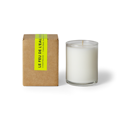 Experience the 3oz Chartreuse glass candle, blending Cassia Bark, Sandalwood, and Frankincense- three kingly scents commingle for mystical moments of transition and delight. Hand-poured in LA, cruelty-free, with coconut apricot wax, natural fragrance, and lead-free cotton wicks. No harmful additives. The candle is displayed unboxed, positioned beside its packaging, set against a clean white backdrop.