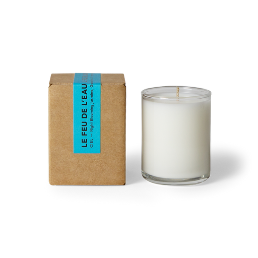  Indulge in the 3oz Ciel glass candle, blending night blooming jasmine, gardenia and musk. Hand-poured in LA, cruelty-free, with coconut apricot wax, natural fragrance, and lead-free cotton wicks. No harmful additives. The candle is displayed unboxed, positioned beside its packaging, set against a clean white backdrop.